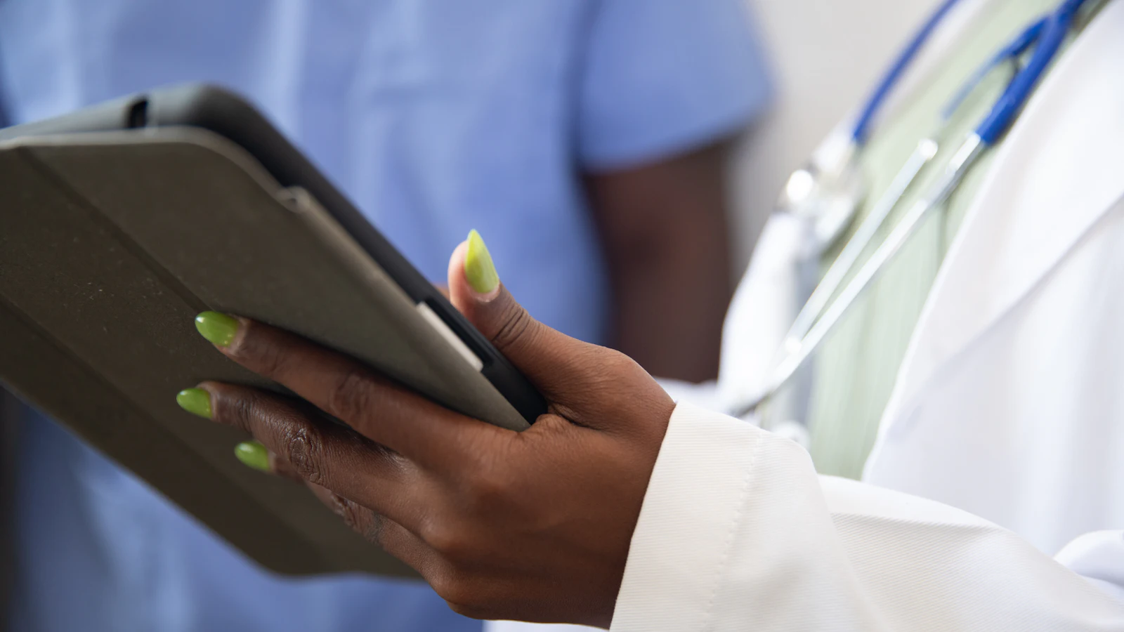 A doctor holding a tablet with digital health records